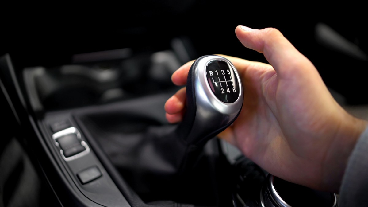 hand on the manual gearbox of a stick shift 