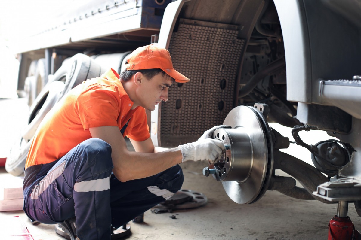 Mechanic working on the brakes of a truck 
